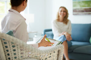 A woman participates in a session of internal family systems therapy with a therapist.